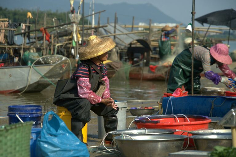Fishermen working to sort and prepare their catch at a busy bustling fish market.