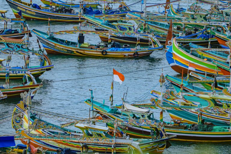 Vibrant traditional fishing boats docked in Jawa Timur, Indonesia, showcasing rich cultural designs and colors.